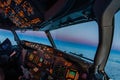 Airplane cockpit atmosphere flying towards the oncoming night at dusk. Pilot perspective on beautiful sunset from inside the Royalty Free Stock Photo