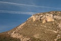 Airplane, contrails of another airplanes and cliff.