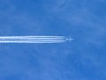 Airplane with contrails in clear blue sky, Cruising altitude