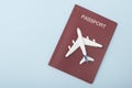 Airplane on the cover of the red passport. Travel concept. Blue