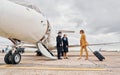 Airplane crew leads woman in yellow clothes inside of a plane Royalty Free Stock Photo