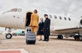 Airplane crew leads woman in yellow clothes inside of a plane Royalty Free Stock Photo