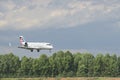 Airplane descends from sky onto runway.