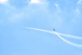 Airplane doing acrobatics in blue sky leaves a smoke. Blue sky with airport contrail clouds Royalty Free Stock Photo