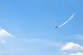 Airplane doing acrobatics in blue sky leaves a smoke. Blue sky with airport contrail clouds Royalty Free Stock Photo