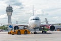 Airplane execute push back operation at airport, on the background ATC tower.