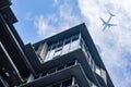 An airplane flies over modern buildings in the city Royalty Free Stock Photo
