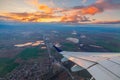 Airplane flight in sunset sky over city and wing of plane. View from the window of the Aircraft. Traveling in air Royalty Free Stock Photo