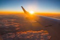 Airplane flight in sunset sky over earth of city light and wing of plane. View from the window of the Aircraft. Traveling in air