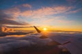 Airplane flight in sunset sky over ocean water and wing of plane. View from the window of the Aircraft. Traveling in air Royalty Free Stock Photo