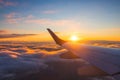 Airplane flight in sunset sky over ocean water and wing of plane. View from the window of the Aircraft. Traveling in air Royalty Free Stock Photo