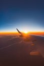 Airplane flight in sunset sky over ocean water and wing of plane. View from the window of the Aircraft. Traveling in air Royalty Free Stock Photo