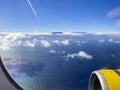 Airplane flight. Wing of an airplane flying above the clouds and sea in La Palma, Canary Islands. View from the window of the Royalty Free Stock Photo