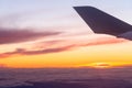 Airplane flight. Wing of an airplane flying above the clouds with sunset sky. View from the window of the plane Royalty Free Stock Photo