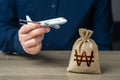 Airplane flights and South Korean won money bag. Airline industry income. Budget allocations Royalty Free Stock Photo