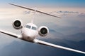 Airplane fly over clouds and Alps mountain on sunset. Front view of a big passenger or cargo aircraft, business jet Royalty Free Stock Photo