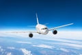 Airplane fly over the clouds and the earth`s surface under the blue sky. Royalty Free Stock Photo