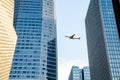 Airplane fly over modern office buildings in downtown Royalty Free Stock Photo