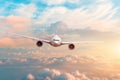 Airplane flying above evening light above the clouds at sunset Royalty Free Stock Photo