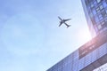 Airplane flying above glass office buildings and futuristic design Royalty Free Stock Photo