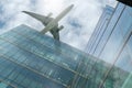 Airplane flying above modern office building. Exterior facade of skyscraper building. Business trip. Reflection in transparent Royalty Free Stock Photo