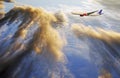 Airplane flying above sunset clouds