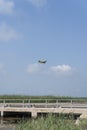 Airplane flying above a wheat field and blue sky with picturesque clouds Royalty Free Stock Photo