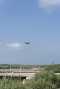 Airplane flying above a wheat field and blue sky with picturesque clouds Royalty Free Stock Photo