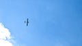 Airplane flying in the blue sky on background of white clouds, rear view. Twin-engine commercial plane during the turn, vacation Royalty Free Stock Photo