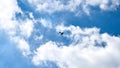 Airplane flying in the blue sky on background of white clouds, rear view. Twin-engine commercial plane during the turn, vacation Royalty Free Stock Photo