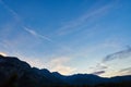 Airplane flying in the blue sky among clouds, sunlight and mountains at sunset. Austria, Salzkammergut. Austrian Alps Royalty Free Stock Photo