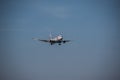 Airplane flying in blue sky with a few clouds