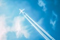 Airplane flying in a blue sky leaving a trail Royalty Free Stock Photo
