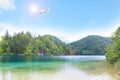 Airplane flying in blue sky over river and mountains Royalty Free Stock Photo