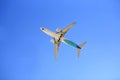 Airplane flying on blue sky. Seen from below Royalty Free Stock Photo