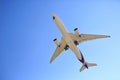 Airplane flying on blue sky. Seen from below Royalty Free Stock Photo