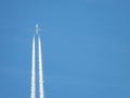 Airplane flying in the clear blue sky and contrail against, Engine exhaust contrails forming behind,  Jet contrails or trails over Royalty Free Stock Photo