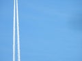 Airplane flying in the clear blue sky and contrail against, Engine exhaust contrails forming behind,  Jet contrails or trails over Royalty Free Stock Photo