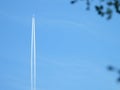 Airplane flying in the clear blue sky and contrail against, Engine exhaust contrails forming behind,  Jet contrails or trails over Royalty Free Stock Photo