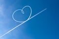 Airplane flying through clear blue sky left heart shape of vapour trails behide Royalty Free Stock Photo