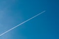 Airplane flying through clear blue sky with vapour trails Royalty Free Stock Photo