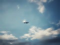 An airplane flying through a cloudy blue sky Royalty Free Stock Photo