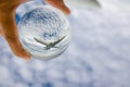 Airplane flying on cloudy sky photography in clear crystal glass ball. Royalty Free Stock Photo