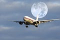 Airplane flying in front of moon Royalty Free Stock Photo