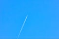 Airplane flying high in clear blue sky with contrail Royalty Free Stock Photo