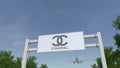 Airplane flying over advertising billboard with Chanel logo. Editorial 3D rendering Royalty Free Stock Photo