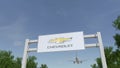 Airplane flying over advertising billboard with Chevrolet logo. Editorial 3D rendering