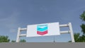 Airplane flying over advertising billboard with Chevron Corporation logo. Editorial 3D rendering Royalty Free Stock Photo