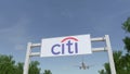 Airplane flying over advertising billboard with Citigroup logo. Editorial 3D rendering