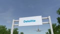 Airplane flying over advertising billboard with Deloitte logo. Editorial 3D rendering Royalty Free Stock Photo